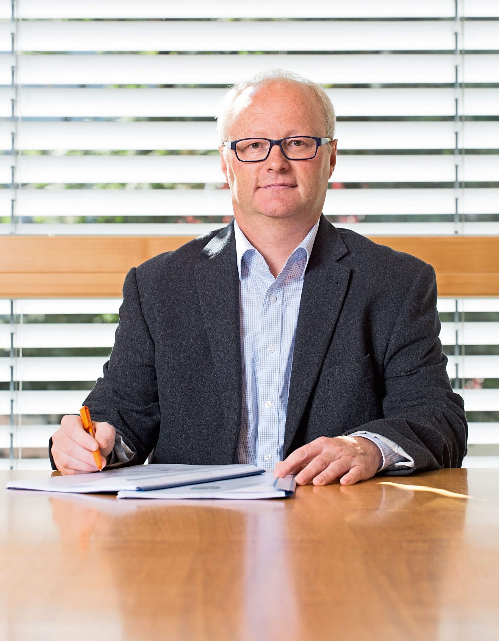 Portraitaufnahme Mann mit Brille, am Tisch sitzend