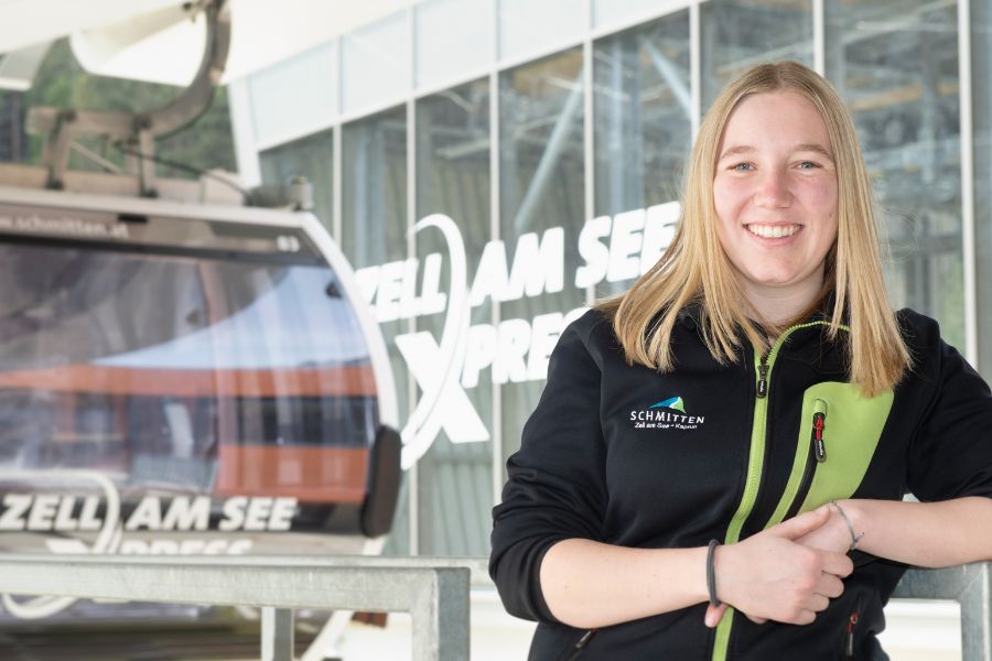 Junge Frau postiert vor Seilbahnkabine
