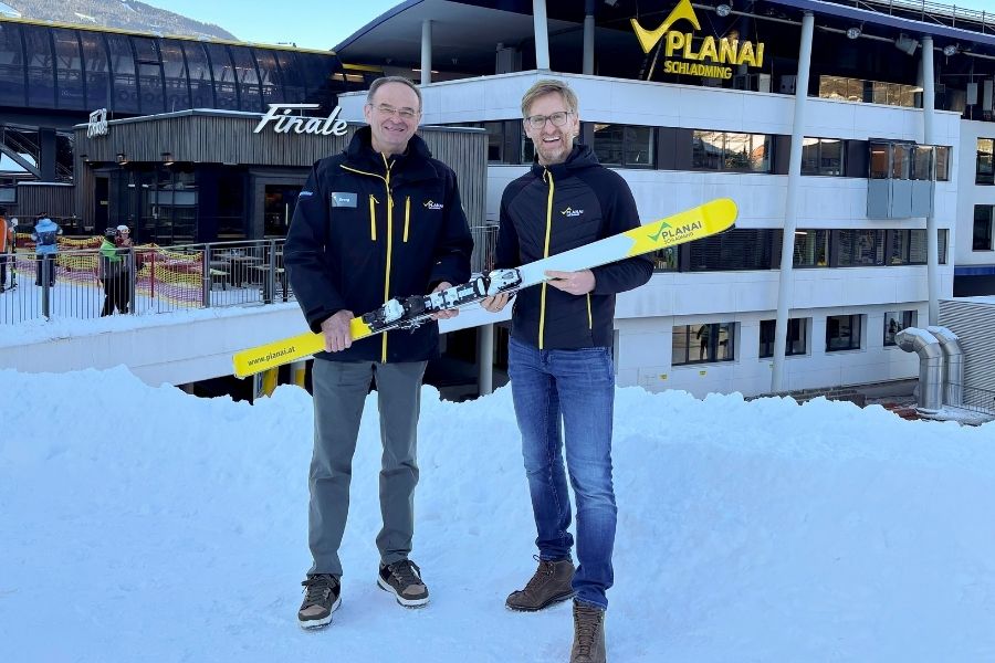 Zwei Männer im Stehen präsentieren, in den Händen haltend, einen Ski