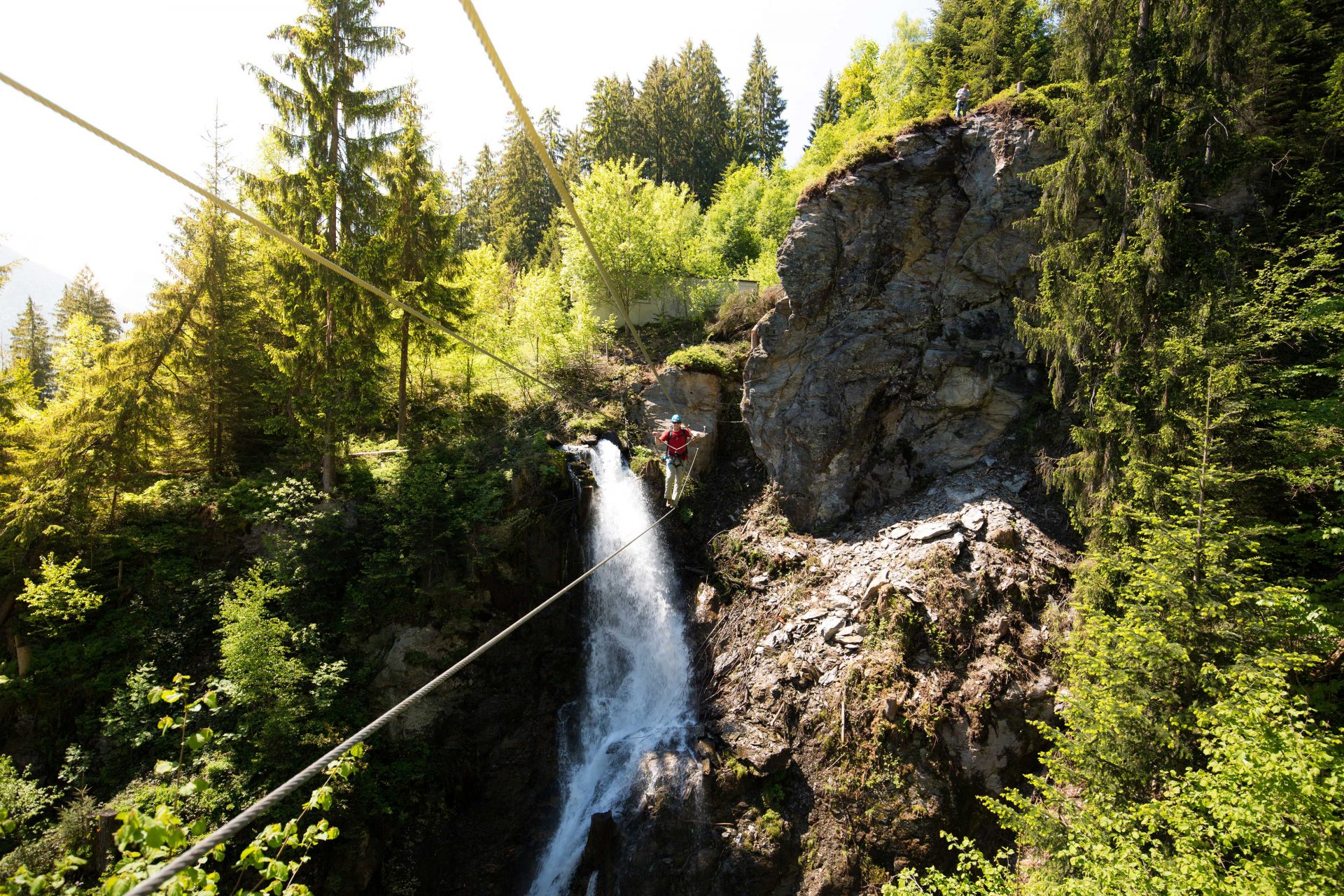 Kletterer überquert Klettersteig bei Wasserfall