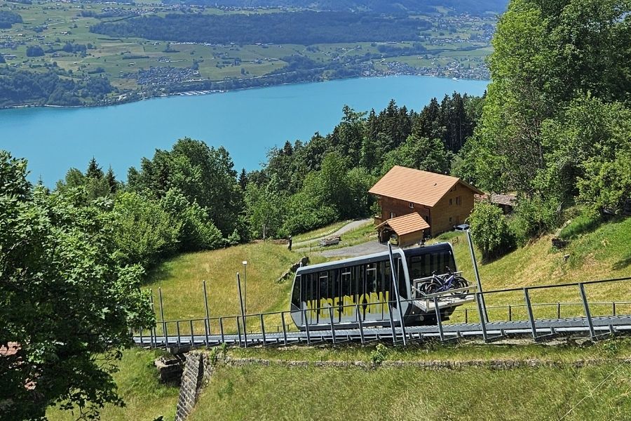 Standseilbahn bei der Fahrt, See im Hintergrund, im Sommer